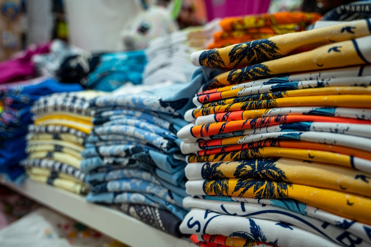 Neatly stacked, freshly laundered shirts on a shelf