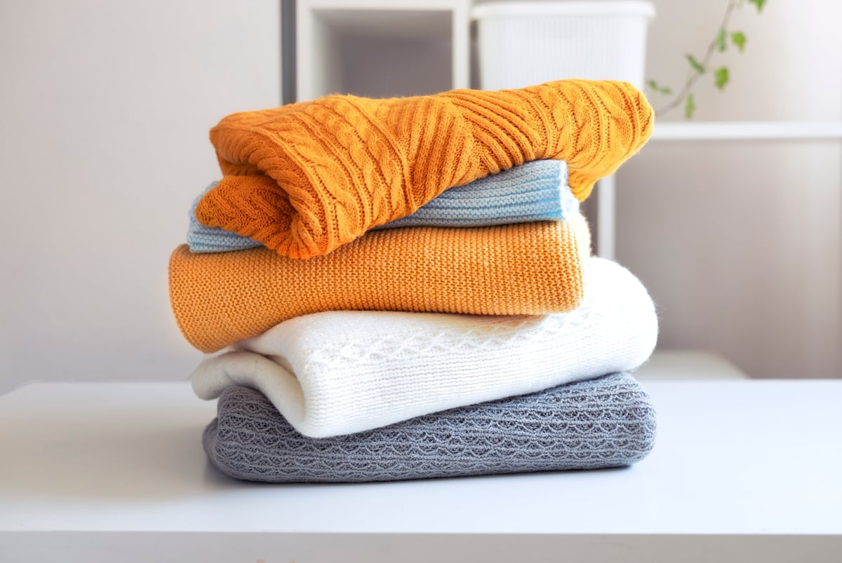 Stack of folded knitted sweaters on a table